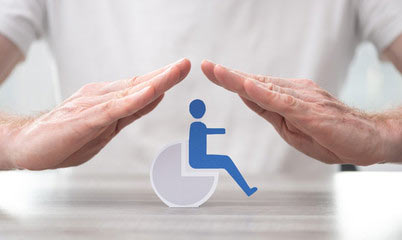 a close up image of two hands forming a roof over a handicapped symbol