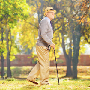 Senior walking with a cane in a park